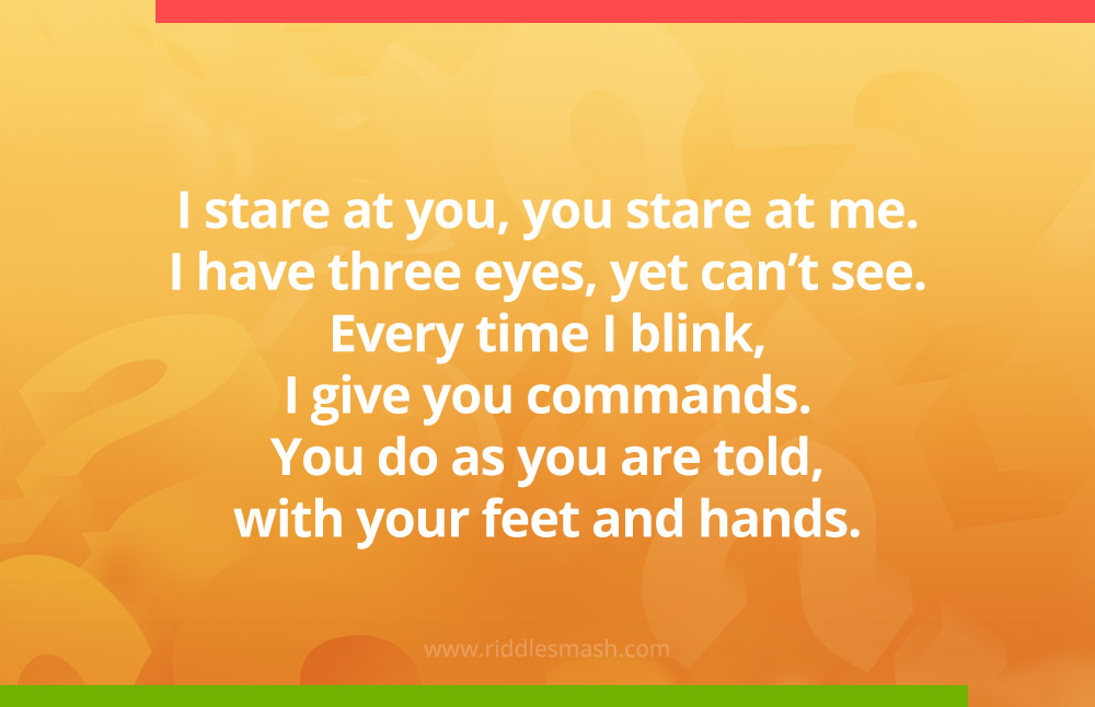 I stare at you, you stare at me. I have three eyes, yet can't see. Every time I blink, I give you commands. You do as you are told, with your feet and hands. What am I?